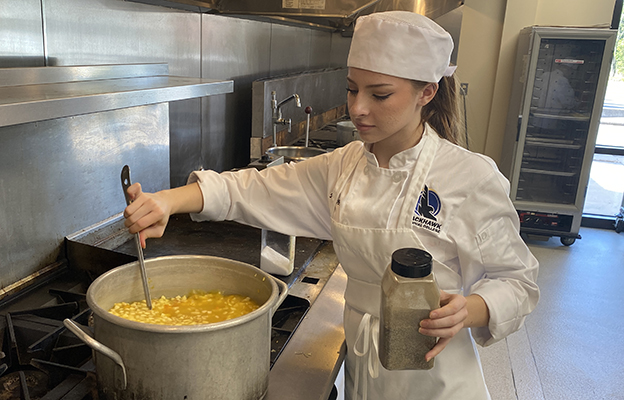 Culinary Arts student stirring a big pot of soup